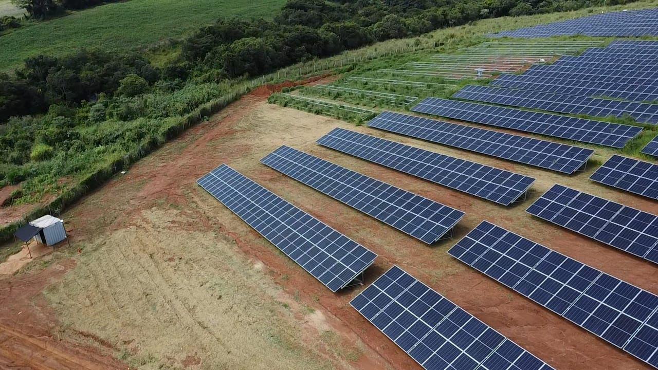 Vista aérea de uma usina fotovoltaica em área rural brasileira